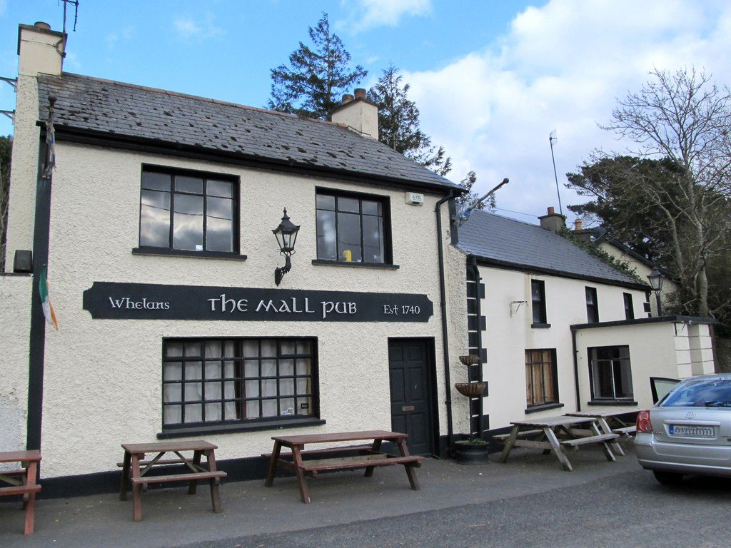 The Mall pub: a white building with a black sign and picnic benches out front